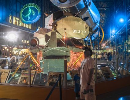 Kai and Kenny looking up at the other business end of the Saturn V. The end that carried the people. The end that went there and back again. While the Lunar Module glitters uncannily, just over their shoulders.